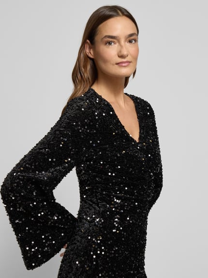 Frauenmodel trägt Minikleid mit Pailletten Modell 'BARINA' von Vila, schwarze Textur, V-Ausschnitt, Nahaufnahme Oberkörper.