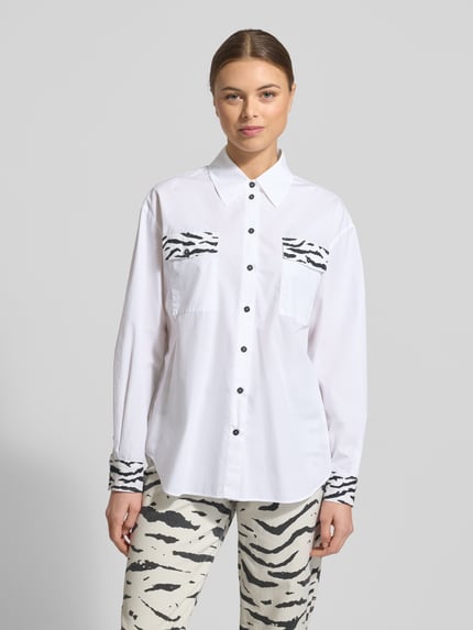 Frauenmodel trägt Hemdbluse mit Knopfleiste von Marc Cain in Weiß mit Zebramuster, Reine Baumwolle, Lockerer Schnitt, Hemdblusenkragen, Ganzkörperansicht von vorne.