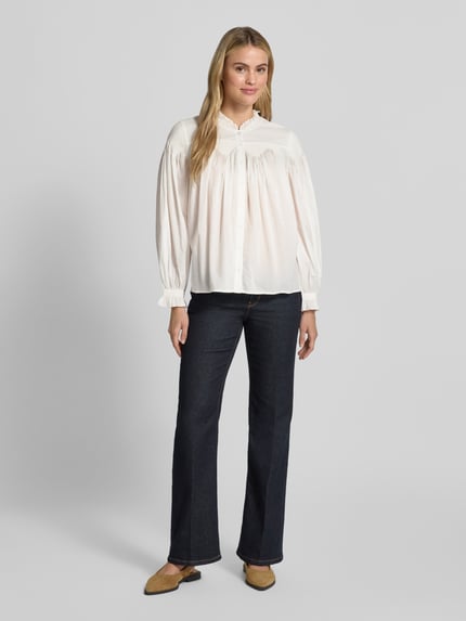 Frauenmodel trägt Regular Fit Bluse mit Stehkragen Modell 'TONIA' von ba&sh, reine Baumwolle, weiße Farbe, dunkle Hose, Ganzkörperansicht von vorne.