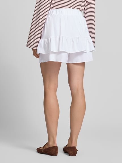 Männermodel trägt weißen Ausgestellter Skort aus Leinen-Baumwoll-Mix Modell 'PIPPA' von VILLA SOPHIE, strukturierte Optik, Ganzkörperansicht Rückansicht.