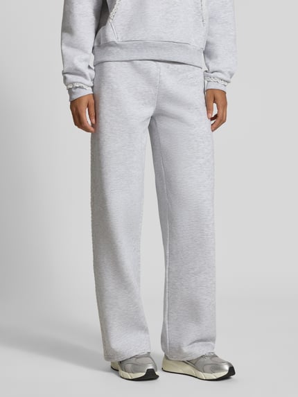 Frauenmodel trägt Sweatpants mit Häkelspitze von REVIEW in Hellgrau, gerader Schnitt, elastischer Bund, Material-Mix, Nahaufnahme Unterkörper.