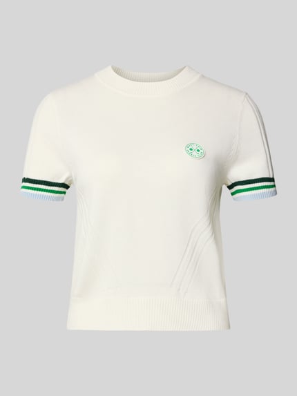 Produktfoto, Regular Fit T-Shirt mit Woll-Anteil von Marc Cain, Damen T-Shirt im Baumwoll-Mix mit Woll-Anteil, Strick-Optik, Logo-Applikation, Rundhalsausschnitt, Farbe Offwhite, feine Struktur, kurze Ärmel mit grün-weißen Bündchen, Rückenlänge 48 cm, Ärmellänge 16 cm.