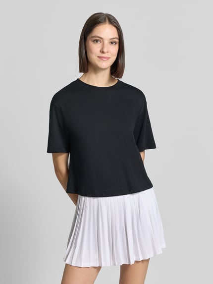 Frauenmodel trägt Relaxed Fit T-Shirt aus Baumwoll-Mix von Fabletics in Schwarz, kurzer Schnitt, Rundhalsausschnitt, Nahaufnahme Oberkörper.