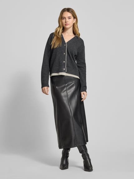 Frauenmodel trägt Cardigan aus Wolle mit V-Ausschnitt Modell 'Tracy' von My Essential Wardrobe, Regular-Fit, Knopfleiste, Reine Wolle, Rückenlänge 55 cm, Ärmellänge 57 cm, dunkelgrau, glatte Struktur, Ganzkörperansicht von vorne.