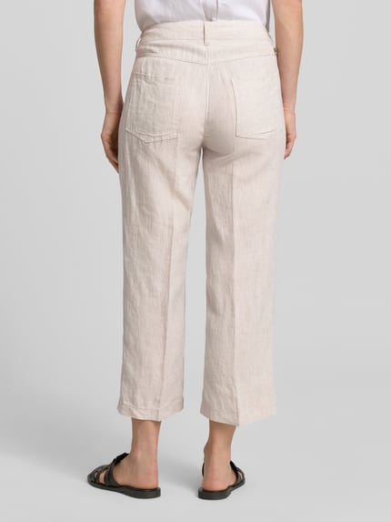 Modelka kobieca nosi Culotte aus Leinen mit Eingrifftaschen Modell 'Nora' von MAC, szerokość w rozmiarze 36: 44 cm, krój wide leg fit, długość nogawki od wewnątrz: 67 cm, francuskie kieszenie, len, beżowy odcień, tekstura lnu, widok całej sylwetki z tyłu.