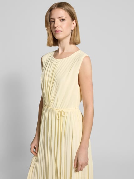 Kobiece model prezentuje Regular Fit Kleid mit Plissee od s.Oliver BLACK LABEL, efekt: jednolity kolor, krój regular fit, długość midi, okrągły dekolt, wszyty zamek błyskawiczny, taśma do wiązania, bez rękawów, wykończenie materiału: plisy. Ujęcie: z przodu, do połowy sylwetki.