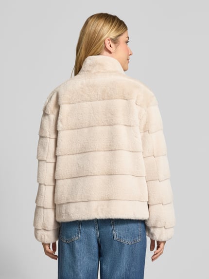 Vrouwenmodel draagt Regular Fit Jacke aus Kunstfell van PETITE M., crèmekleur, doorgestikte naden, opstaande kraag, ruglengte maat 36 57 cm, schouderbreedte 42 cm, borstwijdte 56 cm, mouwlengte 57 cm, geheel afgebeeld van achteren.