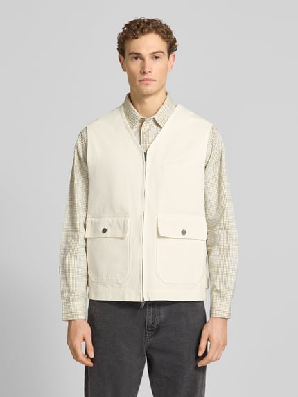 Mannenmodel draagt Weste met Tweewegs-ritssluiting Modell 'Bow' van Wood Wood, katoenen relaxed fit, crème, V-hals, opgestikte kleppenzakken, vooraanzicht bovenlichaam.