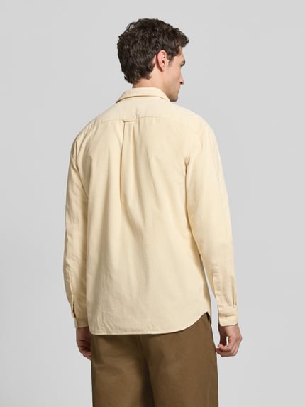 Männermodel trägt Regular Fit Cordhemd mit Logo-Applikation von LACOSTE, unifarben, Struktur, Knöpfe, Kragen, Ganzkörperansicht Rückansicht.