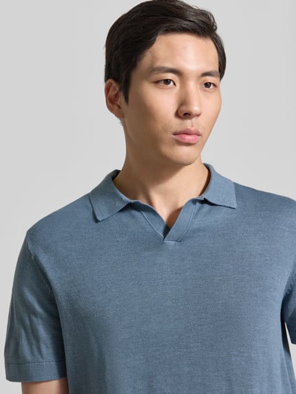 Männermodel trägt Regular Fit Poloshirt aus Baumwoll-Leinen-Mix Modell 'MATTIS' von SELECTED HOMME, unifarben, Nahaufnahme Oberkörper.