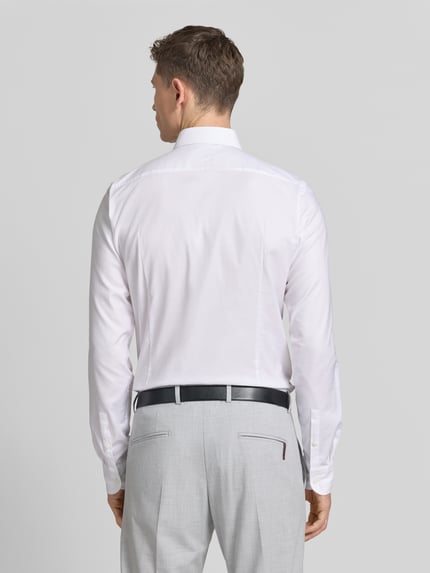 Männermodel trägt Regular Fit Businesshemd mit extra langem Arm von BOSS aus Baumwoll-Mix, unifarben, Ganzkörperansicht Rückansicht.