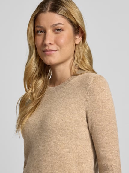 Frauenmodel trägt Strickpullover mit 1/2-Arm und Rundhalsausschnitt von Christian Berg Woman, beige Farbe, reine Baumwolle, Slim Fit, Nahaufnahme Oberkörper.