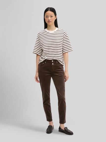Frauenmodel trägt Boyfriend Fit Cordhose aus Baumwoll-Mix von Marc O'Polo in Braun, Damen Cordhose, weiße Wand, Ganzkörperansicht von vorne.