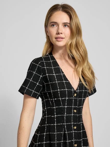 Vrouwenmodel draagt tailliertes Etuikleid mit Gitterkaro-Muster Modell 'KIKLA' van HUGO, bouclé, V-hals, korte mouw, close-up bovenlichaam.