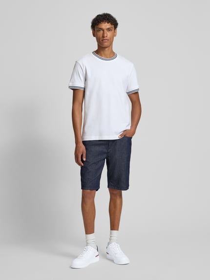 Męski model nosi Bermudas im 5-Pocket-Design Modell 'Fort' od JOOP! Collection w kolorze granatowym, bawełna ze stretchem, krój straight fit, Szerokość w rozmiarze 32: 43 cm, długość nogawki wewnętrznej: 24 cm, pełna sylwetka z przodu.