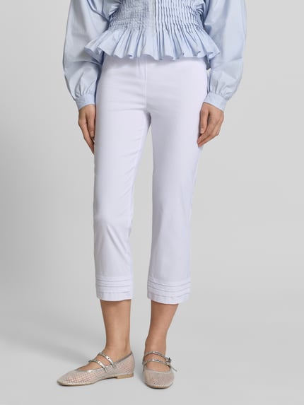 Vrouwenmodel draagt Caprihose aus Viskose-Mix Modell 'Ina' van STEHMANN, slim fit, lichte kleur, stretchmateriaal, draperieën, detailopname onderlichaam.