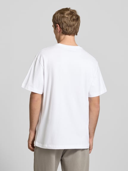 Männermodel trägt weißes T-Shirt mit Logo-Stitching von The North Face aus reiner Baumwolle, gerader Schnitt, Ganzkörperansicht Rückansicht.