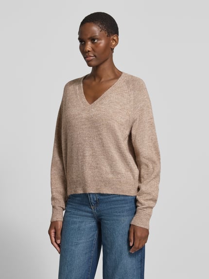 Frauenmodel trägt Pullover mit V-Ausschnitt VMTEAK von VERO MODA in beige Melange, Strickoptik, Cropped, lange Raglanärmel, Ganzkörperansicht von vorne