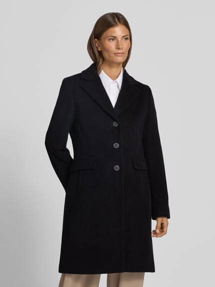 Vrouwenmodel draagt Mantel aus Woll-Mix mit Reverskragen und Pattentaschen van FUCHS SCHMITT in zwart, straight fit, knoopsluiting, klepzakken, mix van wol en kasjmier, ruglengte maat 36: 95 cm, schouderbreedte: 42 cm, borstwijdte: 48 cm, mouwlengte: 66 cm, geheel aanzicht van voren.