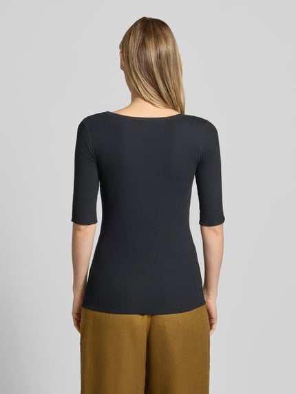 Modelka nosi T-Shirt mit Ärmelaufschlag und Rundhalsausschnitt von Marc Cain, czarny bawełniany mix ze stretchem, krój slim fit, gładka tekstura, długość tyłu 62 cm, całkowity widok z tyłu