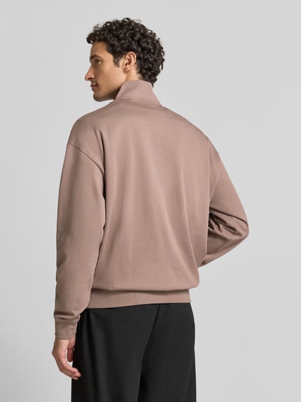 Männermodel trägt Regular Fit Troyer aus Baumwoll-Mix Modell 'Dalizip' von HUGO in Braun, schlichtes Design, Ganzkörperansicht Rückansicht. Herren Troyer von HUGO