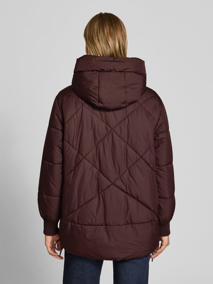 Frauenmodel trägt Relaxed Fit Steppmantel mit Kapuze von Marc O'Polo in Dunkelbraun, gesteppte Struktur, Damen Steppmantel, Ganzkörperansicht Rückansicht.