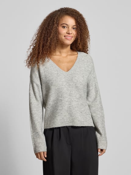 Frauenmodel trägt Regular Fit Strickpullover mit Paillettenbesatz Modell 'ARIZONA' von Only in Melange-Optik, Nahaufnahme Oberkörper.