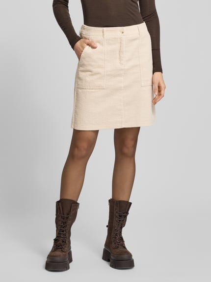 Vrouwenmodel draagt Minirock met Eingrifftaschen Modell 'Reah' van OPUS in crème katoen, los model, voorkant, heup- en achterzakken, detailopname.