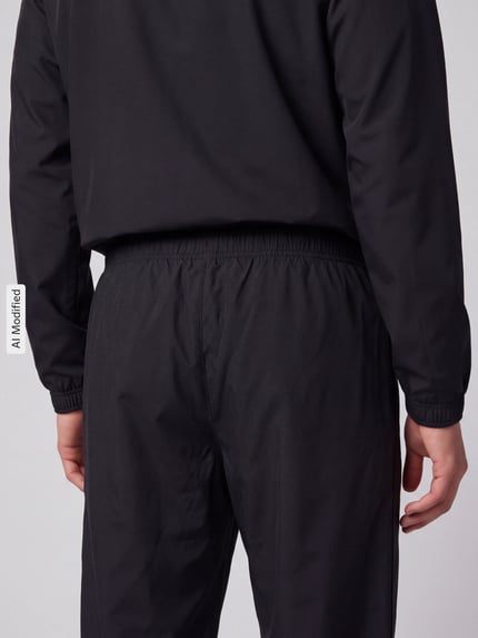 Männermodel trägt schwarze Regular Fit Trainingshose mit Logo-Patch von Lacoste, Textur glatt, Ganzkörperansicht Rückansicht, Herren Trainingshose von Lacoste Sport, KI-modifiziertes Bild.