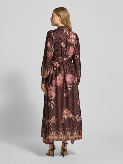 Frauenmodel trägt Maxikleid aus Satin mit Bindegürtel von Neo Noir, floraler Print in Braun und Rosa, A-Linie, Ganzkörperansicht Rückansicht.