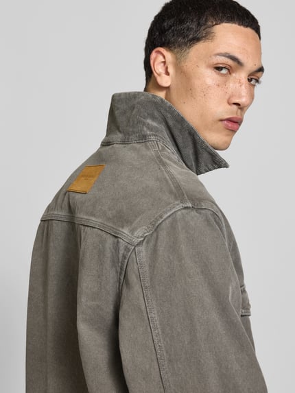 Männermodel trägt Strickjacke aus Alpaka Wolle von Officine Générale in grauer Denim-Optik mit Umlegekragen, Nahaufnahme Rückansicht.