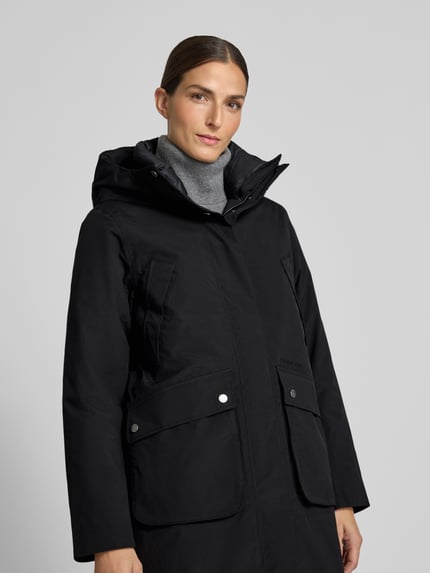 Frauenmodel trägt Regular Fit Parka mit Kapuze Modell 'Melody' von Didriksons in Schwarz mit aufgesetzten Taschen, Nahaufnahme Oberkörper. Rückenlänge 111 cm, Schulterbreite 42 cm, Brustweite 53 cm, Ärmellänge 65 cm.