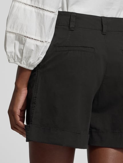 Vrouwenmodel draagt Relaxed Fit Shorts uit katoenmix model 'TANESSA-D' van BOSS Orange, effen zwart met paspelzakken, detailopname rugaanzicht.