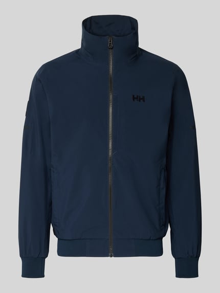 Produktfoto, Bomberjacke mit Stehkragen Modell 'RACING' von Helly Hansen in Dunkelblau, Reißverschluss, Logo-Print, gerippte Abschlüsse, prosta linia, kieszenie boczne, długość tyłu w rozmiarze M: 68 cm, szerokość ramion w rozmiarze M: 43 cm, szerokość w klatce piersiowej w rozmiarze M: 58 cm, długość rękawa w rozmiarze M: 68 cm
