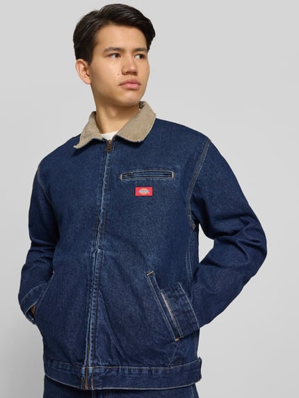Männermodel trägt Jeansjacke mit Label-Detail und Reißverschluss von Dickies aus Reine Baumwolle, Regular-Fit, Nahaufnahme Oberkörper.