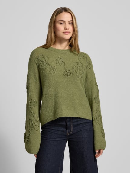 Frauenmodel trägt Strickpullover mit Stitchings Modell 'Miabelle Hope' von MSCH Copenhagen in Olivgrün, Relaxed Fit, Nahaufnahme Oberkörper.
