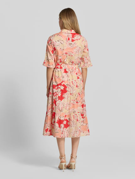 Frauenmodel trägt Hemdblusenkleid aus Reine Viskose Modell 'FALDINE' von Soyaconcept, florale Muster in Rot und Beige, Midikleid, Umlegekragen, Knopfleiste, Bindegürtel, 3/4-Arm, Taillierte Passform, Rückenlänge bei Größe S: 120 cm, Brustweite 48 cm, Ärmellänge 36 cm, Ganzkörperansicht Rückansicht