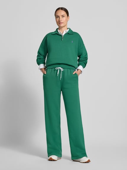 Kobiece model prezentuje zielone spodnie Wide Leg Sweathose aus Baumwoll-Mix mit Logo-Stitching od Polo Ralph Lauren, widok całej sylwetki z przodu, spodnie damskie.