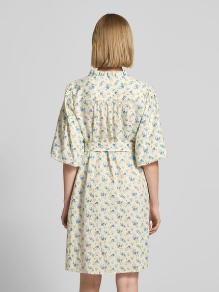 Vrouwenmodel draagt knielang dames jurk van linnenmix met viscose van MSCH Copenhagen, model 'Solfried', getailleerd, halflange mouwen, opstaande kraag met ruches, ruglengte maat S 96 cm, borstwijdte 84 cm, mouwlengte 37 cm, lichte kleur met blauw bloemenpatroon. Ganzkörperansicht Rückansicht.