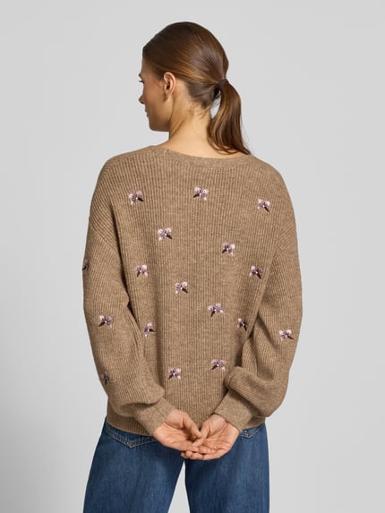 Frauenmodel trägt Relaxed Fit Strickjacke aus elastischem Woll-Mix Modell 'FLEUR' von YAS, florale Stickerei, braun, Rückenansicht.
