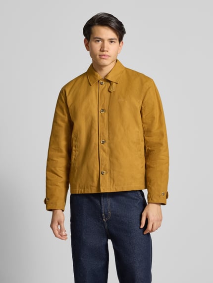 Männermodel trägt Jacke mit Label-Stitching und Eingrifftaschen von BLKVIS, senfgelb, reine Baumwolle, Regular Fit, Ganzkörperansicht von vorne.