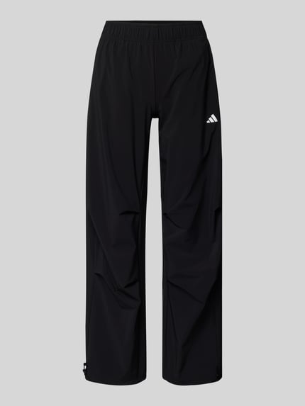 Produktfoto, Wide Fit Stoffhose mit Logo-Print von adidas Sportswear, schwarz, weiter Schnitt, elastischer Bund, glatte Textur, frontal.