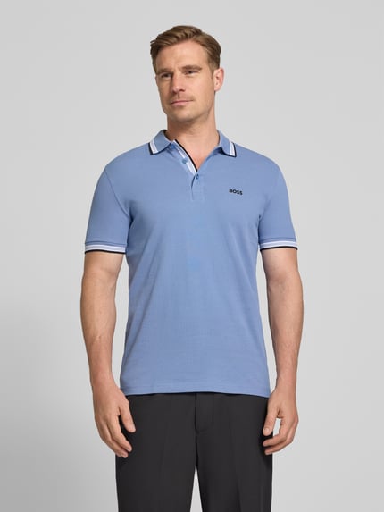 Męski model nosi Regular Fit Poloshirt aus reiner Baumwolle Modell 'PADDY' od BOSS Green, kolor jednolity, krój regular fit, bawełniany piqué, detal z logo, polokołnierzyk, trzy guziki, krótkie rękawy; widok całej sylwetki z przodu.