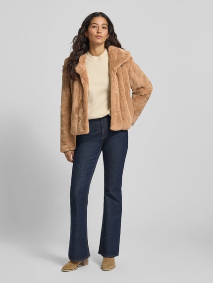 Frauenmodel trägt Jacke aus Kunstfell Modell 'NEW SOPHY' von Guess, Regular-Fit, Schalkragen, Beige, weiche Textur, Ganzkörperansicht von vorne. Rückenlänge bei Größe S: 56 cm, Schulterbreite: 44 cm, Brustweite: 46 cm, Ärmellänge: 59 cm.