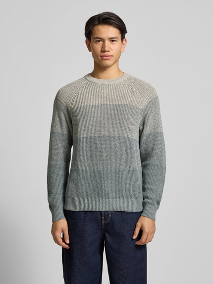Männermodel trägt Relaxed Fit Strickpullover aus reiner Baumwolle Modell 'BIRK' von Only & Sons in Ombré-Melange-Optik mit Rundhalsausschnitt und gerippten Abschlüssen, Stricktextur, Ganzkörperansicht von vorne.