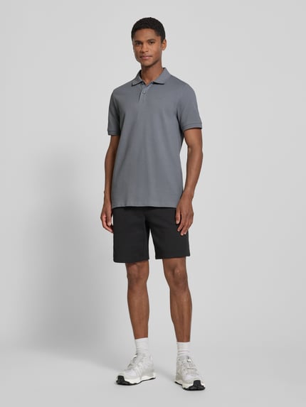 Männermodel trägt Regular Fit Poloshirt aus reiner Baumwolle von s.Oliver RED LABEL in Grau, dezente Textur, Ganzkörperansicht von vorne.