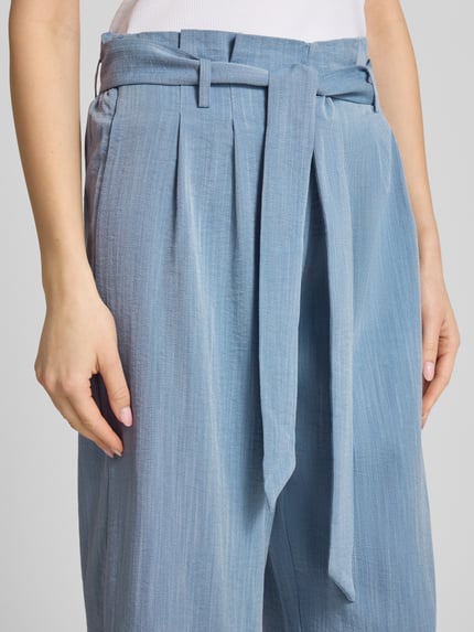Frauenmodel trägt Regular Fit Bundfaltenhose aus Viskose-Mix Modell 'MARSA' von Only, Optik: Unifarben, Bindegürtel, Nahaufnahme Oberkörper.
