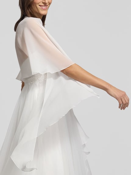 Frauenmodel trägt Stola aus Chiffon mit Knopfverschluss von Vera Mont, fließender Stoff, transparentes Weiß, Ganzkörperansicht von vorne.