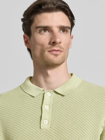 Männermodel trägt Regular Fit Poloshirt mit Label-Detail Modell 'ISAKSSON' von Casual Friday aus katoen in lichtgroen, textuur met wafelstructuur, polokraag, halve mouw, Nahaufnahme Oberkörper.