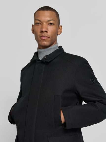 Männermodel trägt Kurzmantel Modell 'DARRY' von JOOP! COLLECTION in Uni-Optik mit Struktur, Stehkragen, Nahaufnahme Oberkörper.